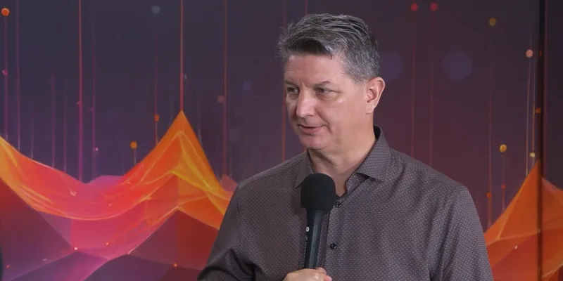 TravelAI CEO John Lyotier speaking into a microphone during a PhocusWire CEO Spotlight interview